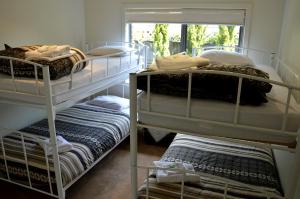 a room with three bunk beds and a window at The Track - beautiful townhouse in Bright in Bright