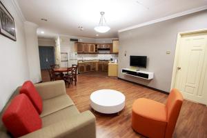 ein Wohnzimmer mit einem Sofa und einem Tisch in der Unterkunft Beta Service Apartment in Labuan