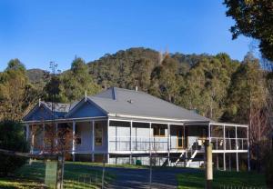 a house with a fence in front of it at Growlers Creek Lodge in Wandiligong