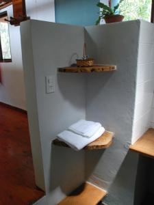 a bathroom with two shelves with towels on a wall at Surucua Reserva & Ecolodge in Comandante Andresito
