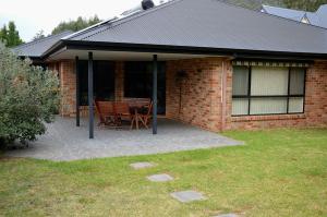 a patio with a table and chairs in front of a house at 12 The Track, Bright in Bright