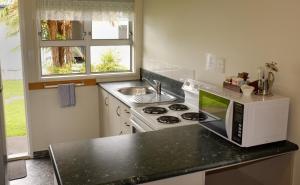 a kitchen with a microwave and a stove at Westport Motels in Westport