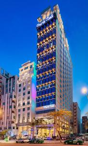 a tall building with lights on the side of it at Paris Deli Danang Beach Hotel in Danang