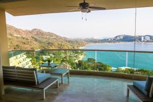 a balcony with chairs and a view of the ocean at B Esmeralda Pichilingue PentHouse in Acapulco