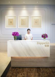 a woman standing at a reception desk in a lobby at Amari Don Muang Airport Bangkok in Bangkok