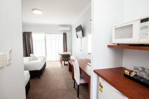 a hotel room with a bed and a room at Springwood Motor Inn in Springwood