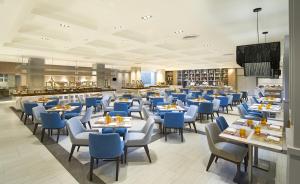 a restaurant with blue chairs and tables in a room at Amari Don Muang Airport Bangkok in Bangkok