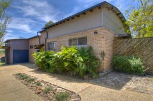 a brick house with a fence in front of it at Blue Beach House, 9 Cross Street, Port Macquarie in Port Macquarie