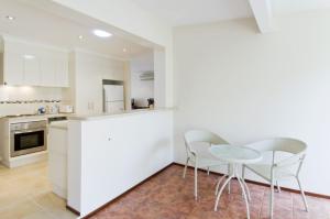 a kitchen and dining room with a table and chairs at Cara Nobbys Beach 11 Wesley Avenue in Port Macquarie