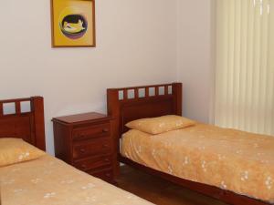 a bedroom with two beds and a night stand at Rocky Beach Cottage 26 Pacific Drive in Port Macquarie