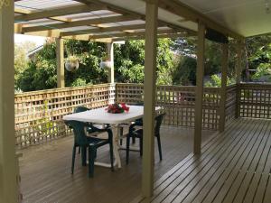 a wooden deck with a table and chairs on it at Rocky Beach Cottage 26 Pacific Drive in Port Macquarie