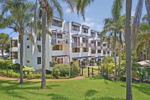 an apartment building with palm trees in a park at Ocean Terrace 6 67 Pacific Drive in Port Macquarie