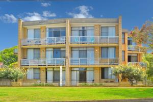 een appartementencomplex met balkons en een gazon bij Flynns Beach Apartments 4 41 Pacific Drive in Port Macquarie