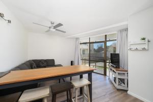 een woonkamer met een tafel en een bank bij Flynns Beach Apartments 4 41 Pacific Drive in Port Macquarie