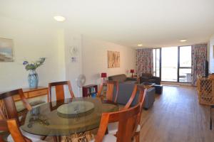 a dining room and living room with a table and chairs at Beachpark 10 58 Pacific Drive in Port Macquarie