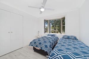 A bed or beds in a room at Aqualuna At Lighthouse Beach 8 Capalla Court