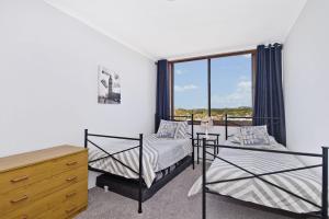 a bedroom with two beds and a dresser and a window at Akuna 18 6 Joffre Street in Port Macquarie