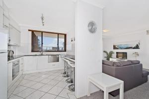 a kitchen and living room with a couch and a table at Akuna 18 6 Joffre Street in Port Macquarie