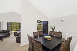 a dining room with a black table and chairs at Amara 6 Wesley Avenue in Port Macquarie