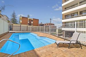 a swimming pool with a chair next to a building at Akuna 18 6 Joffre Street in Port Macquarie