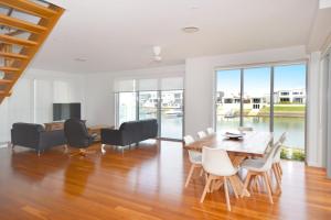 a dining room with a table and chairs and a living room at 4/84 The Anchorage in Port Macquarie