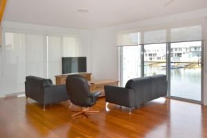 a living room with two chairs and a television at 4/84 The Anchorage in Port Macquarie