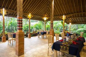 a restaurant with blue tables and chairs and trees at Senetan Villas and Spa Resort in Payangan