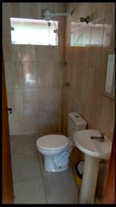 a bathroom with a toilet and a sink at Casas em Boracéia in Boracéia