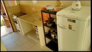 a kitchen with a white refrigerator and a sink at Casas em Boracéia in Boracéia