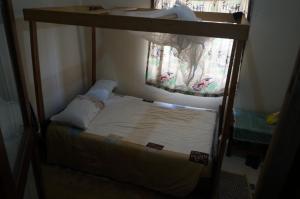 MasakaにあるMasaka Backpackers, Tourists Cottage & Campsiteの窓付きの部屋の二段ベッド1台分です。