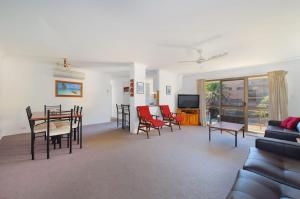 a living room with a table and chairs and a couch at Shelly Cove 13 113 Pacific Drive in Port Macquarie