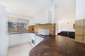 a kitchen with white cabinets and a counter top at Shelly Cove 13 113 Pacific Drive in Port Macquarie