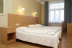 a bedroom with a large bed with a wooden headboard at Guesthouse Jakob Lenz in Rīga