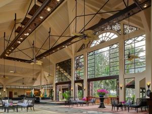 eine große Lobby mit Tischen, Stühlen und Fenstern in der Unterkunft Dusit Thani Laguna Phuket in Strand Bang Tao
