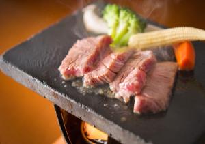 菰野町的住宿－彩向陽酒店，烤架上的两块肉和蔬菜
