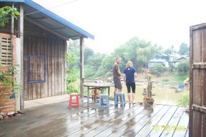 a man and a woman standing on a deck at Wooden House in Battambang