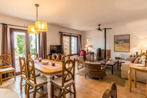 ein Wohnzimmer mit Tisch und Couch in der Unterkunft Vivienda Rural Olivar de San Telmo in Arcos de la Frontera