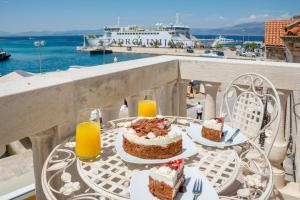 a table with two cakes and orange juice on a balcony at Apartment Barbara in Supetar