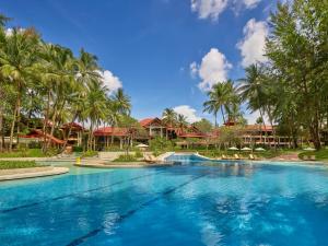 ein Swimmingpool in einem Resort mit Palmen in der Unterkunft Dusit Thani Laguna Phuket in Strand Bang Tao