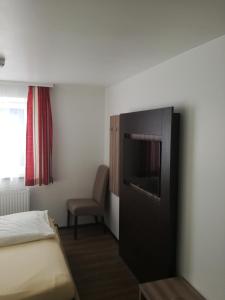 Habitación de hotel con cama y TV de pantalla plana. en Landgasthof zum Betenmacher, en Thalgau