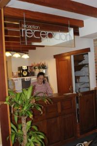 a woman sitting at a counter in a kitchen at Albergue Cabrales in Carreña de Cabrales