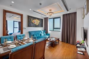 a living room with a blue couch and a table at Paris Deli Danang Beach Hotel in Danang