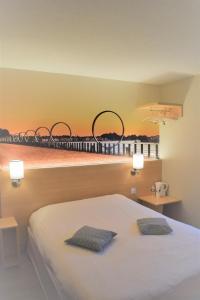 - une chambre dotée d'un lit avec 2 hottes sur le mur dans l'établissement Hôtel Inn Design Resto Novo Châteaubriant, à Châteaubriant