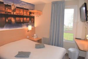 une chambre d'hôtel avec un lit et une fenêtre dans l'établissement Hôtel Inn Design Resto Novo Châteaubriant, à Châteaubriant