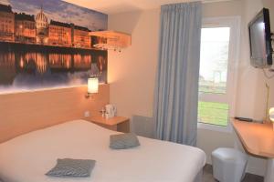 a hotel room with a bed and a window at Hôtel Inn Design Resto Novo Châteaubriant in Châteaubriant