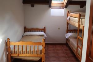 a room with two bunk beds in a house at Albergue Cabrales in Carreña de Cabrales