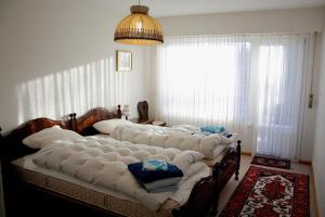 ein Schlafzimmer mit einem großen Bett mit weißer Bettwäsche in der Unterkunft Residence Arnica in Crans-Montana