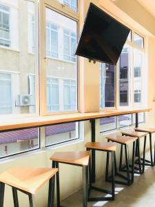 a row of desks in a classroom with windows at The Good Travelers Hostel - KL Airport in Sepang