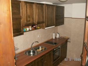 a kitchen with wooden cabinets and a sink at Guest house "The House" in Zlatograd +18 photos
