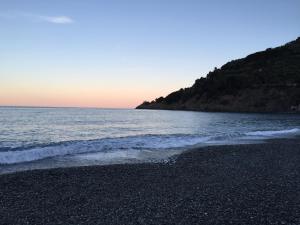 a pebble beach with the ocean in the background at A pochi passi dal mare by PortofinoVacanze in Bonassola